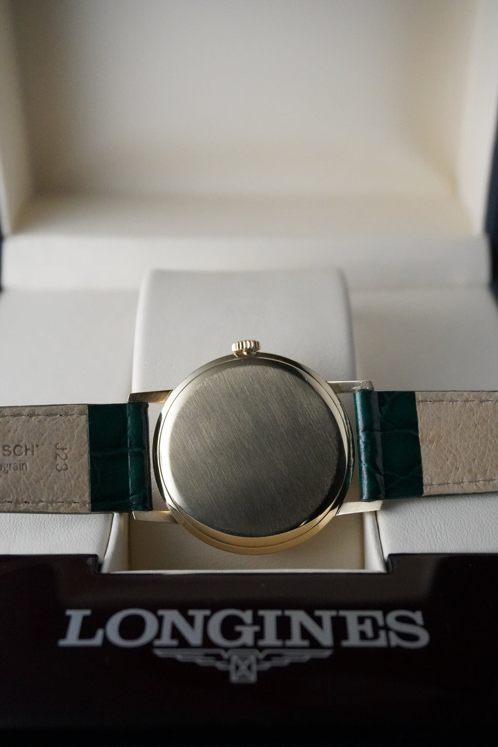 Longines watch with green strap on a white background