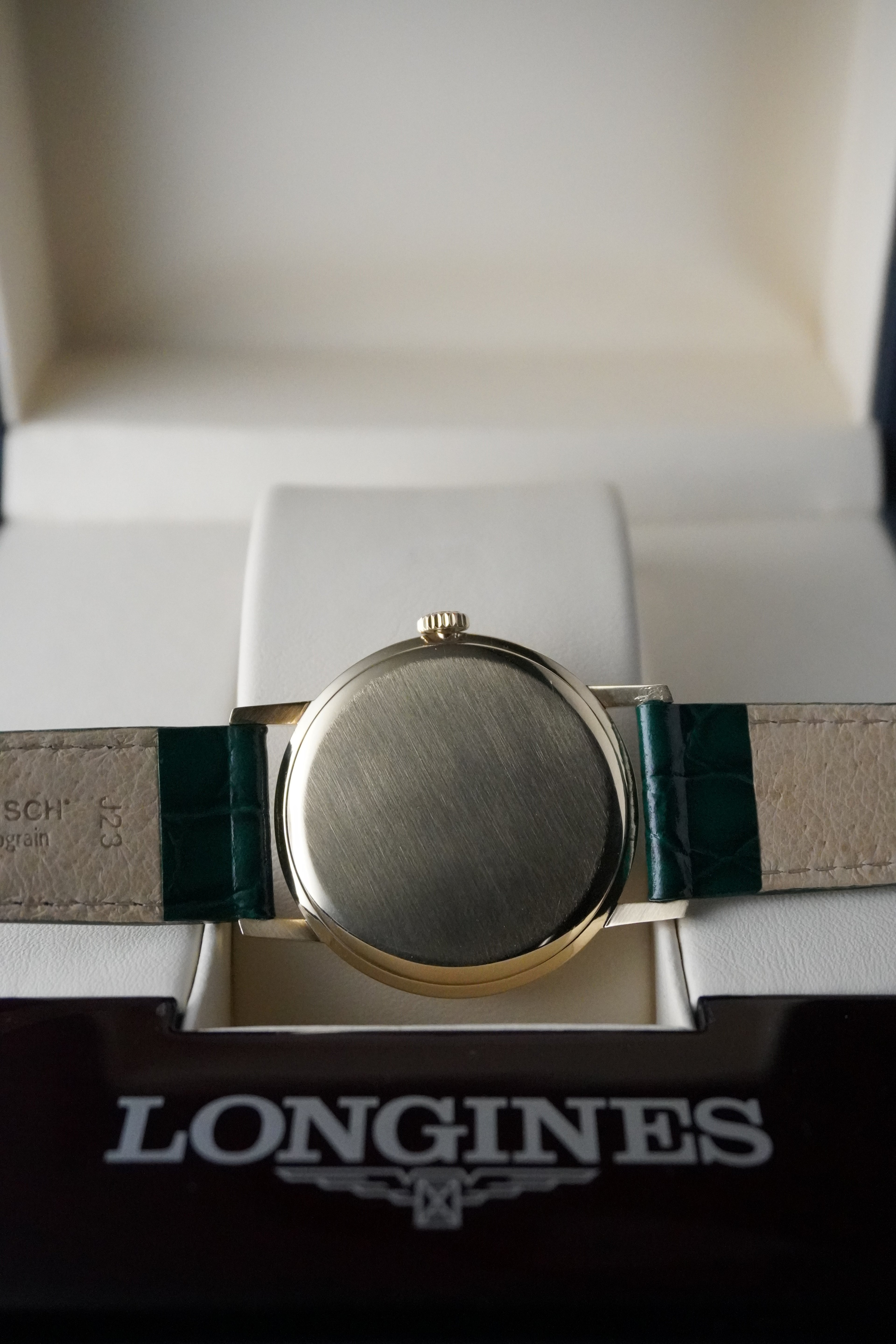 Longines watch with green strap on a white background