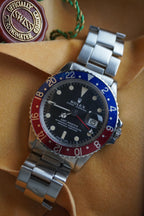 Rolex watch with a silver band, red and blue bezel on a yellow background
