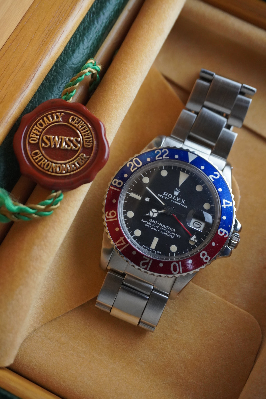 Vintage Rolex GMT-Master Pepsi bezel stainless steel watch with red and blue bezel insert, black dial, and Oyster bracelet displayed in original presentation box with Swiss chronometer seal.