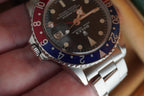 Rolex watch with a red and blue bezel on a person's hand