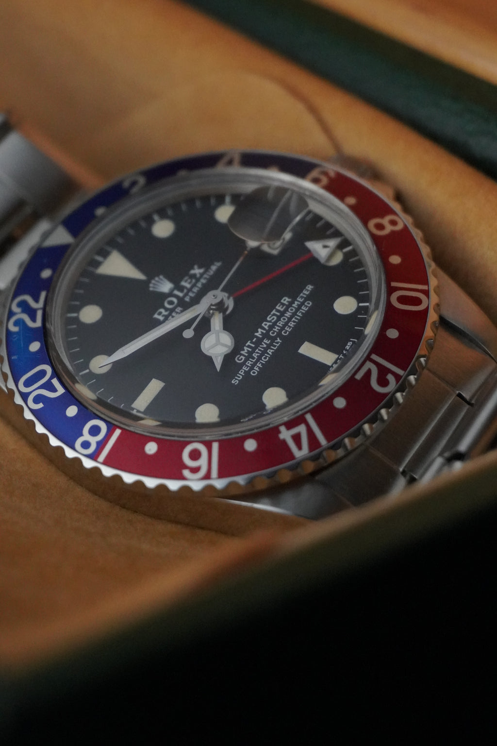 Vintage Rolex GMT-Master Pepsi bezel stainless steel watch with red and blue bezel insert, black dial, and Oyster bracelet displayed in original presentation box with Swiss chronometer seal.
