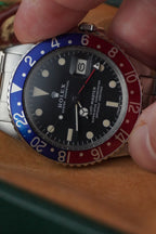 Vintage Rolex GMT-Master Pepsi bezel stainless steel watch with red and blue bezel insert, black dial, and Oyster bracelet displayed in original presentation box with Swiss chronometer seal. 1675
