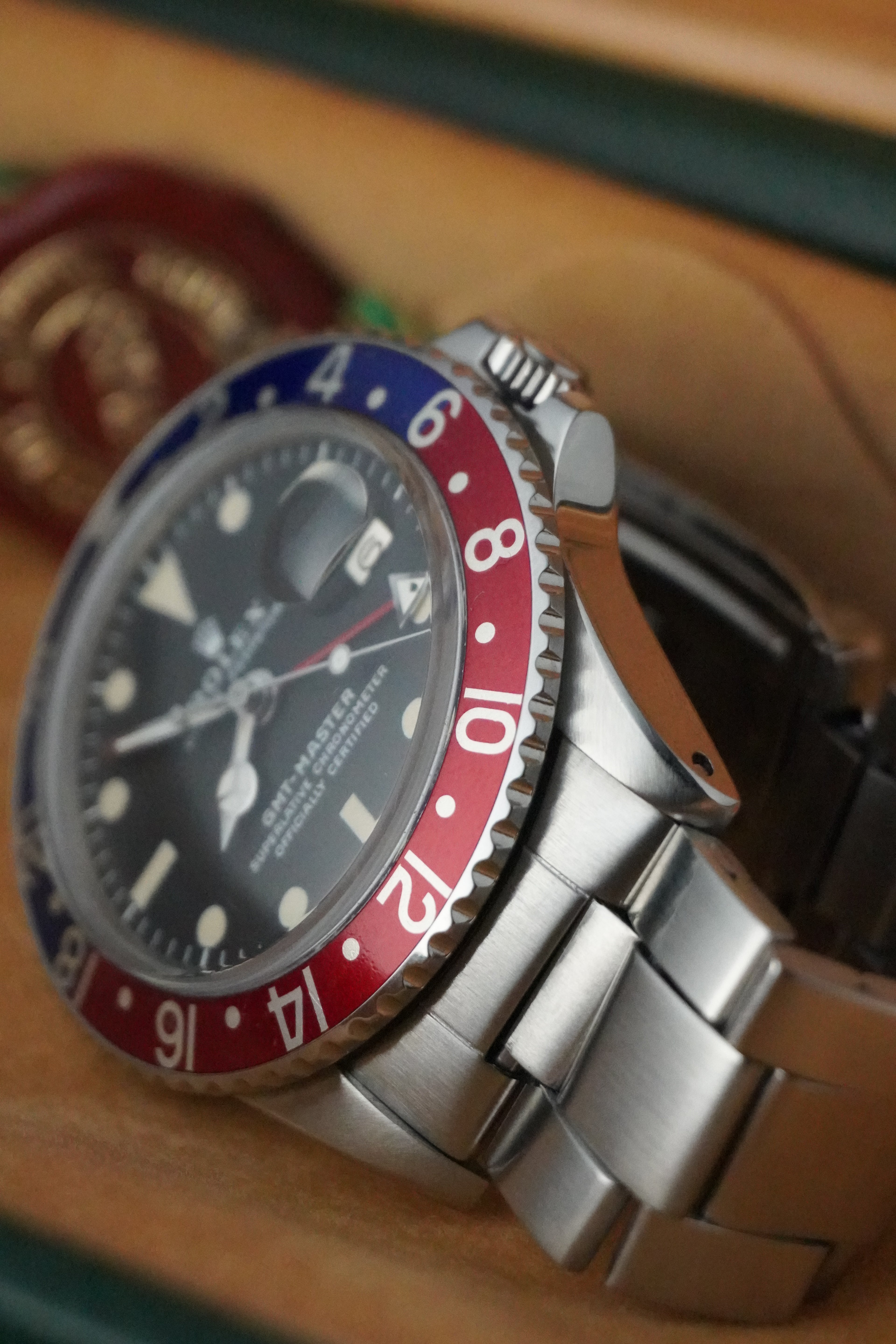 Vintage Rolex GMT-Master Pepsi bezel stainless steel watch with red and blue bezel insert, black dial, and Oyster bracelet displayed in original presentation box with Swiss chronometer seal.